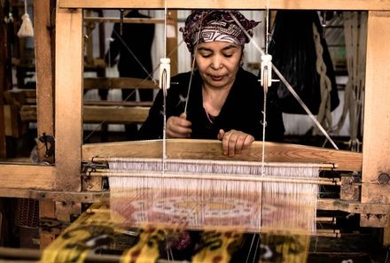 Usbekistan Familienreise - Chiwa - einheimische Frau an Maschine mit Stofffäden
