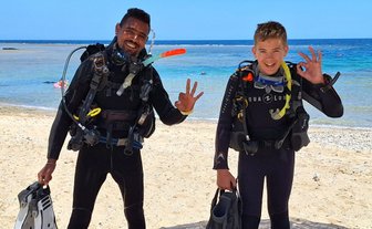 Kind und Guide mit Tauchequipment am Roten Meer - Familienreise nach Ägpyten