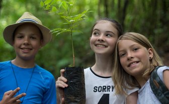 Drei Kinder bereiten Mini-Baum zum Pflanzen vor – Costa Rica Reise mit Kindern