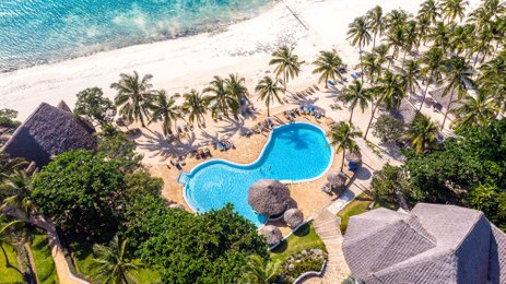 Ein atemberaubender Blick auf den Pool des Karafuu Beach Resorts, umgeben von Palmen und dem glitzernden Ozean.