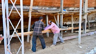 Arbeiter beim Montieren eines traditionellen Bootes in der Dhow-Werft in Sur – Oman Familienreise