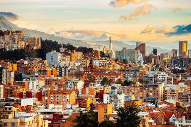 Die Stadt Bogotá zeigt eine beeindruckende Skyline mit modernen Gebäuden und einer malerischen Bergkulisse im Hintergrund.
