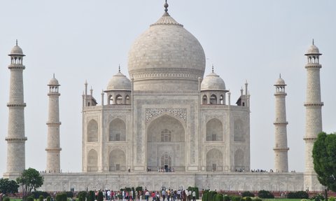 Das majestätische Taj Mahal erhebt sich mit seinen hohen Minaretten und der beeindruckenden Kuppel vor einem klaren Himmel.