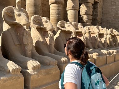 Besucherin steht vor der beeindruckenden Reihe von Widder-Sphinxen im Karnak-Tempel – Ägypten Reise mit Kindern