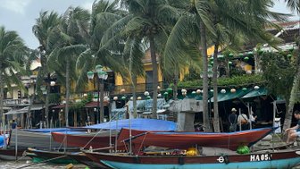 Kleine Boote treiben ruhig auf einem Fluss in Hoi An – Vietnam Familienreise