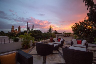 Eine gemütliche Terrasse mit modernen Möbeln bietet einen atemberaubenden Blick auf die bunten Wolken des Sonnenuntergangs.