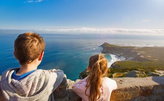 Kinder stehen am Aussichtspunkt des Kaps der Guten Hoffnung und blicken auf das weite Meer – Garden Route Familienreise