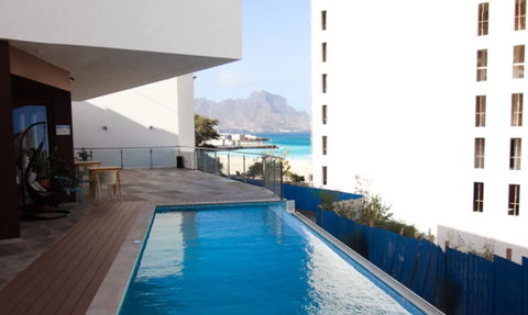 Ein einladender Poolbereich mit klarem Wasser und atemberaubendem Blick auf die Berge und das Meer im Hintergrund.