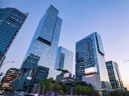 Hochmoderne Wolkenkratzer erheben sich majestätisch gegen den Abendhimmel in Gangnam, Seoul, umgeben von urbanem Leben.