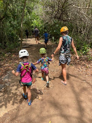 Eine Mutter spaziert mit ihren Kindern auf einem Waldpfad durch den Punta Laguna Park – Mexiko mit Kindern