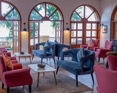 Ein eleganter Lounge-Bereich mit bequemen, farbenfrohen Sesseln und großen Fenstern, die auf eine malerische Aussicht blicken.