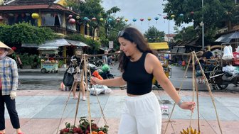 Mädchen trägt frisches Obst in den Straßen von Hoi An – Vietnam Familienreise