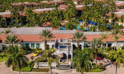 Eine luxuriöse Resortanlage in Florida mit Palmen, einem Poolbereich und eleganten Gebäuden im mediterranen Stil.