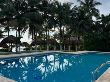 Swimmingpool mit Palmen im Hintergrund in Akumal – Mexiko Familienreise
