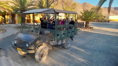 Eine Reisegruppe sitzt gemeinsam in einem offenen Jeep - Namibia mit Kindern