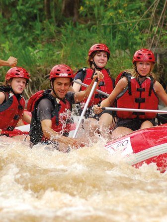 Gemeinsam paddelnde Gruppe im roten Rafting-Boot – Costa Rica Reise mit Kindern