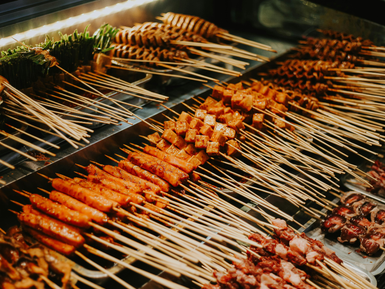 Eine Vielzahl von gegrillten Spießen, darunter Fleisch und Gemüse, die appetitlich auf einem Tisch angeordnet sind.