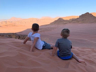Kinder sitzen auf Düne im Wadi Rum - Jordanien mit Kindern