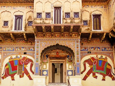Die kunstvoll gestaltete Fassade zeigt bunte Wandmalereien von Elefanten und traditionellen Figuren in lebhaften Farben.