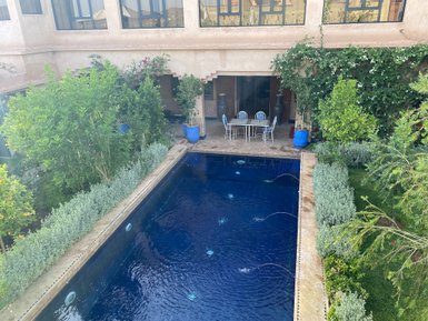 Ein klarer Pool glänzt in der Sonne, umgeben von üppigem Grün und komfortablen Gartenmöbeln für entspannende Stunden.
