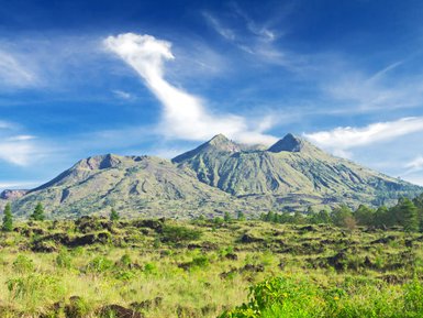 Vulkan Mount Batur mit klar blauem Himmel im Hintergrund – Bali Reise mit Kindern