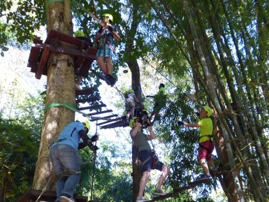 Kinder und Erwachsene klettern im Treetop Adventure Park in Kanchanaburi - Thailand mit Kindern