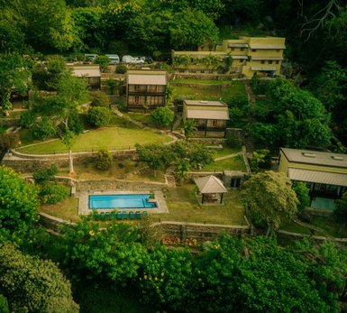 Eine malerische Aussicht auf das Melheim Resort in Haputale, umgeben von üppigem Grün und einem einladenden Pool.
