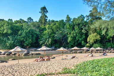 Menschen liegen entspannt am Sandstrand von Khao Lak unter blauem Himmel - Thailand mit Kindern