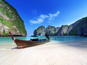 Küstenabschnitt mit Felsformationen und traditionellem Boot – Thailand Reise mit Kindern