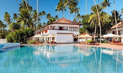 Ein glitzernder Pool umgeben von Palmen und einem eleganten Resort, ideal für entspannende Tage in der Sonne.