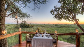 Ein romantisches Abendessen im Freien, umgeben von sanften Wiesen und einem atemberaubenden Sonnenuntergang.