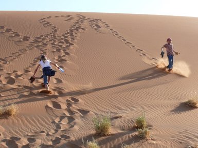 Zwei Kinder spielen auf einer Sanddüne - Namibia Rundreise mit Kindern