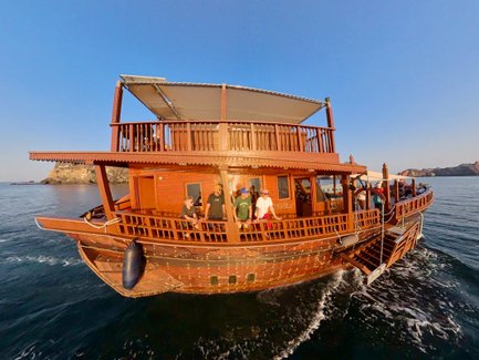 Nahaufnahme eines traditionellen Dhow-Boots auf dem Wasser in Muscat – Oman mit Kindern
