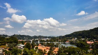 Panoramablick auf die Stadt Kandy mit grüner Landschaft und Häusern im Tal – Sri Lanka Familienreise