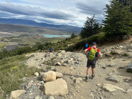 Eine Gruppe von Wanderern erkundet einen steinigen Pfad in der malerischen Landschaft von Torres del Paine.
