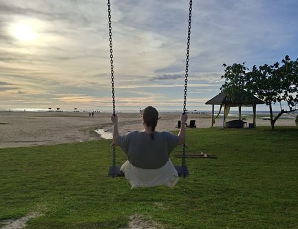 Teenager auf einer Schaukel bei Sonnenuntergang am Strand vom Shangri-La Rasa Ria Resort - Malaysia Familienreise