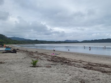 Familien und Besucher genießen einen Spaziergang am Playa Sámara – Costa Rica Reise mit Kindern