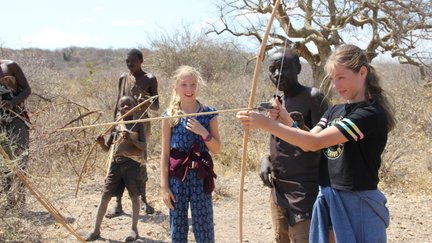 Jugendliche des Hadzabe-Stamms übt Bogenschießen – Tansania mit Kindern