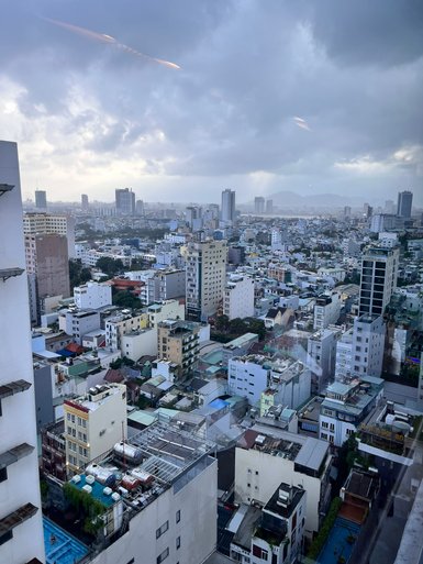 Ein Blick auf die Stadt Da Nang, mit vielen Gebäuden und einem bewölkten Himmel, der eine ruhige Atmosphäre schafft.