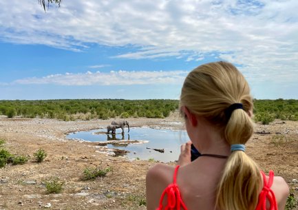 Mädchen macht Foto von zwei Elefanten im Wasserloch - Namibia Urlaub mit Kindern