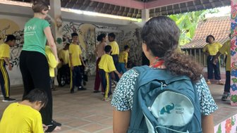 Ein Mädchen trägt einen FFR-Rucksack bei Yayasan Widya Guna – Bali Familienreise