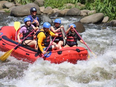 Gruppe paddelt gemeinsam durch starke Stromschnellen – Costa Rica Reise mit Kindern