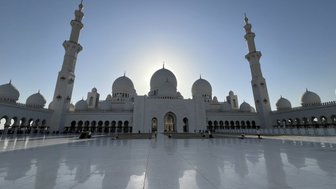 Die beeindruckende Sheikh Zayed Moschee in Abu Dhabi strahlt im Sonnenlicht, ihre Kuppeln und Minarette sind majestätisch.