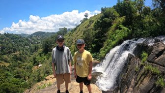 Zwei Kinder stehen vor einem Wasserfall in der bergigen Umgebung von Ella – Sri Lanka Reise mit Kindern