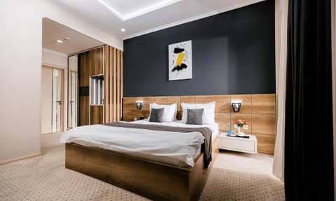 Ein modernes Schlafzimmer mit einem großen Bett, eleganten Nachttischen und einer stilvollen Wandkunst über dem Kopfteil.