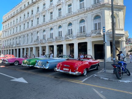 Bunte Oldtimer parken vor einem historischen Gebäude in Havanna - Kuba Reise mit Kindern