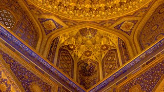 Die kunstvoll gestaltete Decke der Tilya-Kori Medrese zeigt prächtige goldene und blaue Muster, die den Raum erhellen.