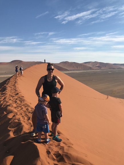 Eine Mutter steht mit zwei Kindern auf einer Sanddüne - Namibia Rundreise mit Kindern