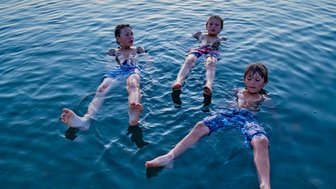 Familie im Toten Meer bei Sonnenuntergang