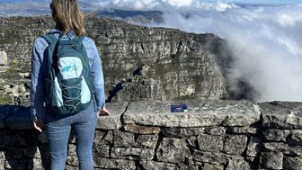 Frau blickt über die Stadt und Küste vom Tafelberg – Südafrika mit Kindern